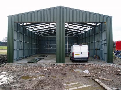 Main building with two entrances clad in dark green steel