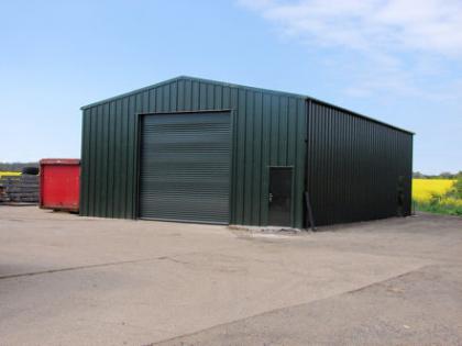 External view of steel framed machine workshop with steel roller door and side door